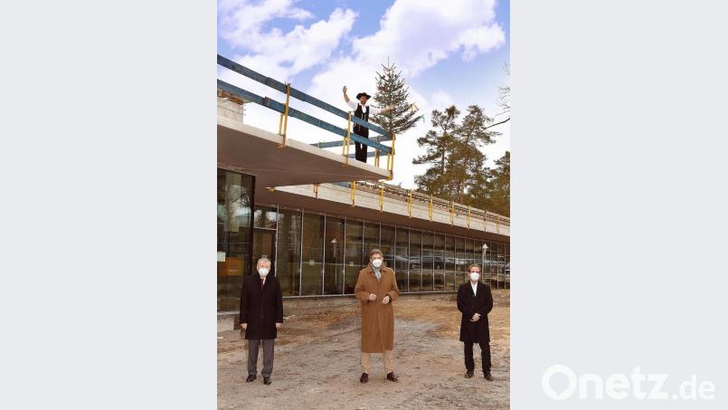 Um den Baufortschritt zu begutachten, trafen sich (vorne, von links) Hauptgeschäftsführer Jürgen Kilger, Handwerkskammer-Präsident Georg Haber sowie Eric Frisch, Vorstand der Dömges Architekten AG. Zimmerermeister Christoph Geiß (oben) sprach den Richtspruch. Bild: Schwarz/exb
