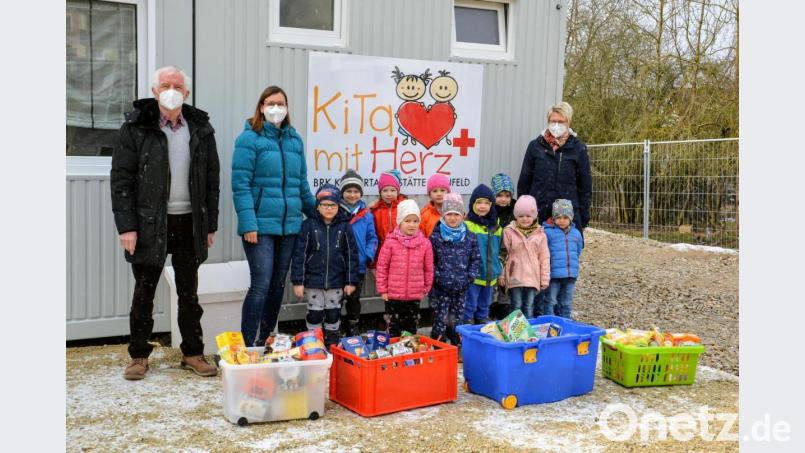 Kinder und Erzieherinnen der Ehenfelder Kita übergeben die Sachspenden für die Amberger Tafel an den Vorsitzenden Bernhard Saurenbach. Bild: fdl