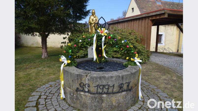 Den Marienbrunnen im Pfarrhof ziert ein österlich geschmückter Bogen. Bild: ak