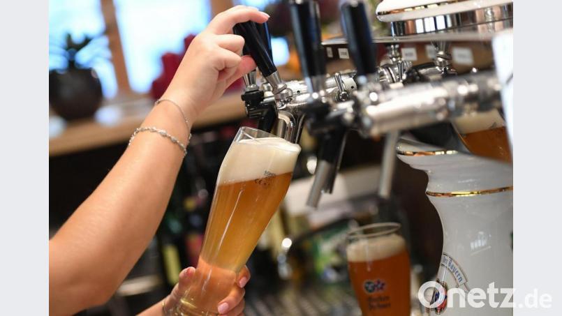 Eine Bedienung zapft Bier in einem Wirtshaus. Bild: Angelika Warmuth/dpa