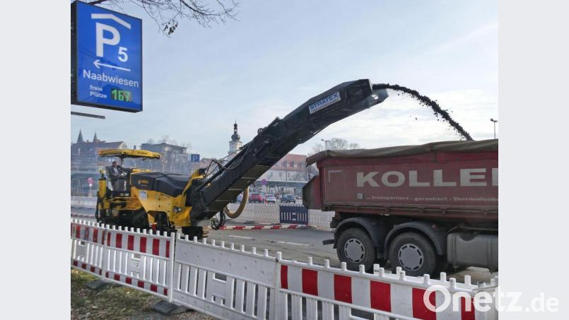 Neben dem Parkdeck Naabwiesen parken die Lastwagen. Auf der Ladefläche landen die Reste des alten Straßenbelags. Bild: Petra Hartl
