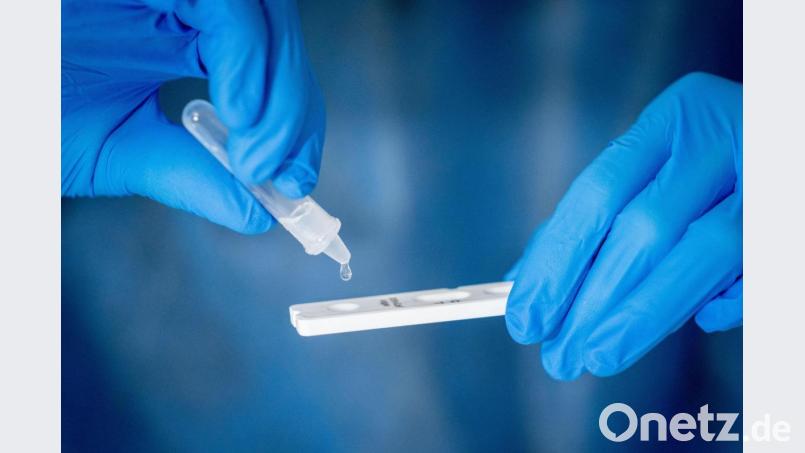 Medizinisch geschultes Personal träufelt nach dem Abstrich für einen Corona-Schnelltest in eine Lösung auf die Antigen Testkasette. Symbolbild: Kay Nietfeld/dpa