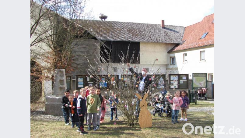 Die Kinder der Blauen Gruppe des Kinderhauses trafen sich mit Bürgermeister Richard Kammerer und hingen noch weitere, mit Glitzersteinchen verzierte Eier an den Strauch. Kammerer dankte vor allem dem Unbekannten, der einen Osterhasen zum Strauch gestellt hat. Bild: sei