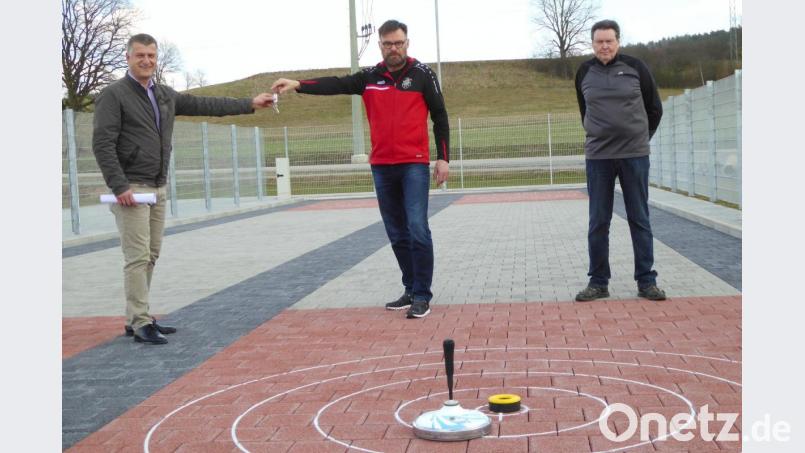 SpVgg-Vorsitzender Josef Schiesl (Mitte) und Stockschützen-Sportwart Karlheinz Ströbert (rechts) bei der Schlüsselübergabe für die Stockbahn durch Bürgermeister Dietmar Schaller. Bild: fsb