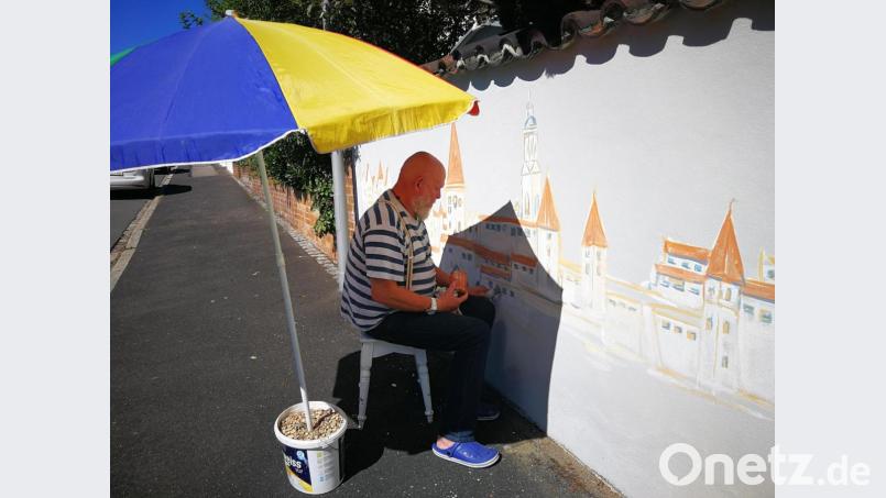 Malen unter erschwerten Bedingungen. Heini Hohl beim Ausgestalten einer Mauer im Eisbergviertel. Bild: ass