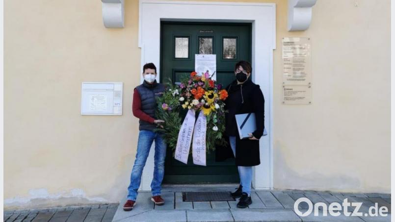 Andrea Burger (links) und Heike Suchanek bei der Übergabe des Trauerkranzes vor dem Rathaus in Bad Neualbenreuth. Bild: Andrea Burger/exb