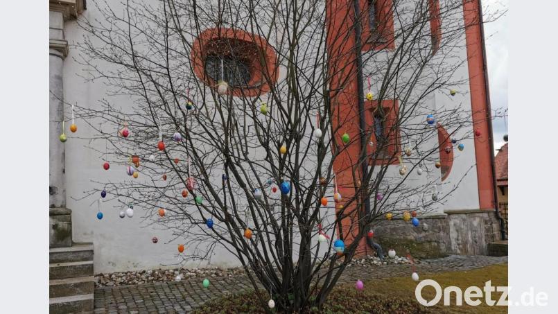 Die Kinder verzierten einen Busch vor der Pfarrkirche mit zahlreichen bunten Eiern. Bild: gz