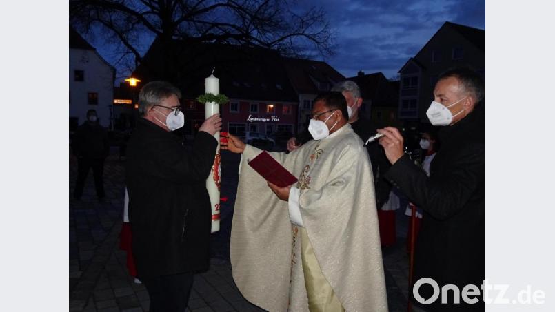 Pater Robin zeigt unser Foto bei der Segnung der Osterkerze Bild: hm