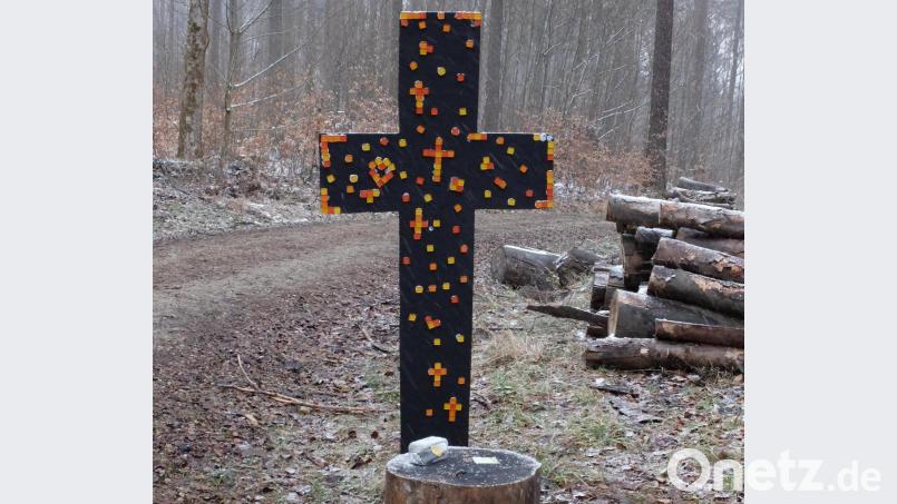 Bunte Steine, die sie in einer Schatzkiste am Osterloch gefunden hatten, klebten die Kinder an ein schwarzes Kreuz, das zum Ausdruck bringt: Jesus hat den Tod überwunden. Bild: Thomas Schertel/exb