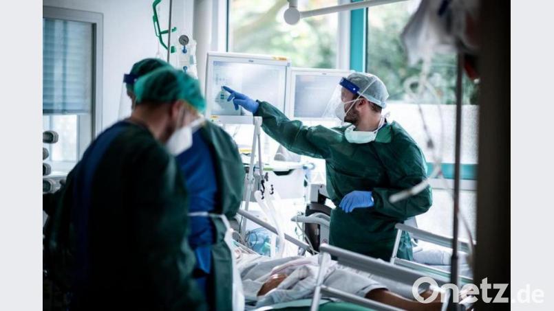 Mitarbeiter der Pflege in Schutzkleidung behandeln einen Patienten mit Corona-Infektion auf einer Intensivstation. Archivbild: Fabian Strauch