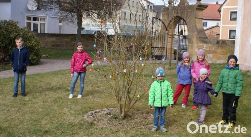 Die Kinder schmückten den Fliederstrauch im evangelischen Kirchgarten und r freuten sich nach einer aufregenden Suche im Kirchgarten über Naschereien. Bild: sei