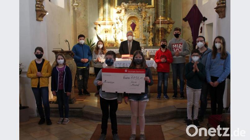 Spendenübergabe der Ministranten. Sie übergeben stolz einen Scheck über 1100 Euro. Bild: Michaela Beer/exb