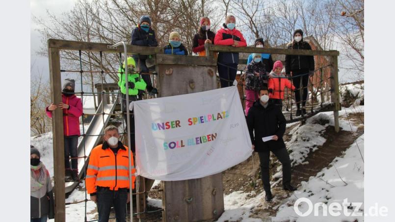 Mit dem Plakat „Unser Spielplatz soll bleiben“ taten die Kinder von Pullenried, unterstützt von ihren Eltern, ihren Willen kund und waren damit erfolgreich. 
Bei Bürgermeister Rudolf Teplitzky und Bauhofchef Hubert Hammerer rechts und links vom Plakat, fanden sie dafür ein offenes Ohr. Bild: frd