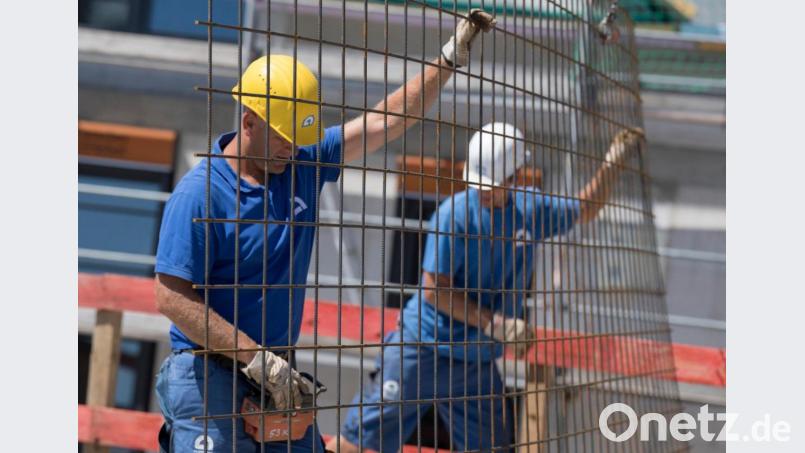 Auf dem Rohbau eines Einfamilienhauses bugsieren Handwerker Stahlmatten in die richtige Position. Der Saisonstart im Bau- und Baunebengewerbe hat auf dem Oberviechtacher Arbeitsmarkt für eine Belebung gesorgt. Symbolbild: Boris Roessler/dpa