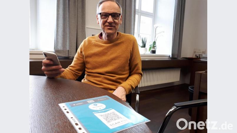 Bürgermeister Bernd Sommer hat die &quot;Waldsassen-App&quot; schon auf dem Smartphone. Auf dem Tisch liegt der Zettel mit dem QR-Code und dem Hinweis &quot;Büro Bürgermeister&quot;. Bild: pz