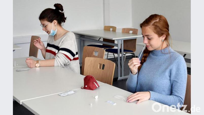 Vor Unterrichtsbeginn machen die Schülerinnen (von links) Paula Fiedler und Laura Dittmar aus der Klasse BFH13A am Berufsschulzentrum einen Selbsttest. In dieser Zeit dürfen sie die Maske abnehmen. Bild: lue