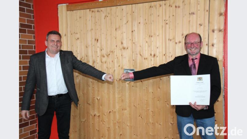 Per „Corona-Handschlag“ gratulierte Bürgermeister Norbert Eckl (links) dem langjährigen Gemeinderat Thomas Wilhelm zur kommunalen Dankurkunde des Freistaates Bayern. Bild: frd