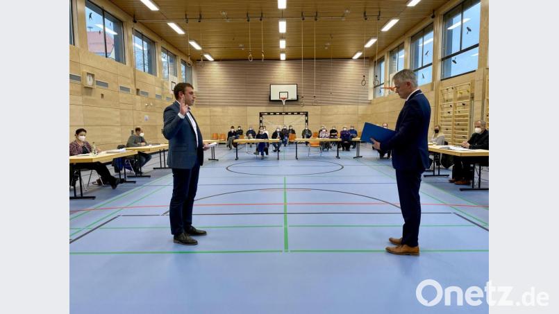 Bürgermeister Thomas Meiler (rechts) vereidigt den FWG-Gemeinderat Stefan Erndt als Nachfolger des ausgeschiedenen Alexander Sailer. Der Gemeinderat tagt erstmals pandemiebedingt in der renovierten Turnhalle. Bild: Eichl