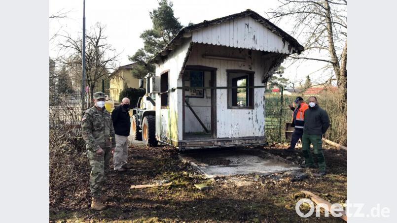 Das alte Wachhäuschen vom Gate 1 auf dem „Rückflug“ ins Lager. Command Sergeant Major Mark Morgan (von links) dankt Chris Irwin, den Arbeitern der Bauabteilung und Hausmeister Thomas Bernhard für die Sicherung des Relikts aus alten Zeiten. Bild: mor