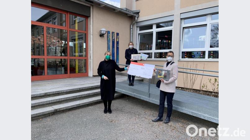 Doppelte Freude: Andrea Froehler, die Leiterin der Albert-Schweitzer-Schule, freut sich über den Scheck des Rotary-Clubs Weiden Max-Reger, den Präsidentin Anja Waertel (rechts) überreicht. Club-Sekretärin Hildegard Ziegler (hinten) bringt zudem Puzzles als Geschenke mit. Bild: Rotary-Club Weiden Max-Reger