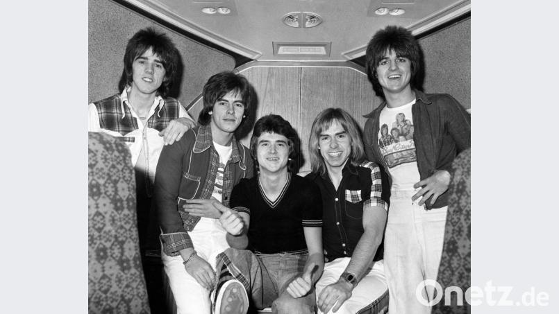 Die Mitglieder der Band &quot;Bay City Rollers&quot; Stuart Wood, Alan Longmuir, Leslie Mckeown, Derek Longmuir und Eric Faulkner (von links) sitzen im November 1975 an Bord Jumbo-Jets auf dem Flughafen London Heathrow vor dem Abflug zu einer Tournee durch Australien. Der Sänger Les McKeown ist im Alter von 65 Jahren gestorben. Bild: Pa/dpa