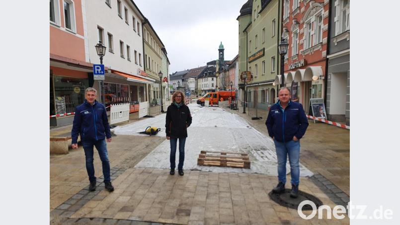 Sachgebietsleiter Christian Frohmader, Ordnungsamtsleiterin Birgit Schelter und Harald Giehl vom Tiefbauamt (von links) begutachten die Arbeiten im Markt, wo das lückenhafte Pflaster neu ausgefugt wird. Sie stehen gerade auf einer der neuen Querungshilfen für Rollstuhlfahrer. Bild: Peggy Biczysko/fph