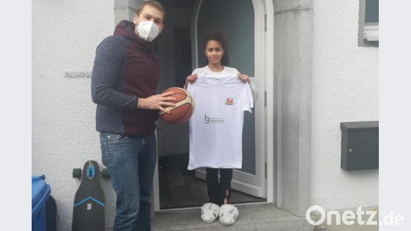 Für den Parcours tauschte Taneesha Thompson (11) ihre Einhornpantoffeln mit Basketballstiefeln. Und meisterte die Aufgaben bravourös. Organisator Stefan Merkl übergibt der U12-Spielerin der DJK – streng nach Coronaregeln – das Sieger-T-Shirt. Bild: DJK Neustadt/exb