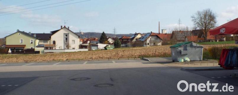 Die landwirtschaftliche Fläche, vom bestehenden Norma-Parkplatz aus Richtung Amberg gesehen, soll bis zu den Häusern bebaut werden soll. Rechts hinten soll ein Doppelwohnhaus entstehen. Bild: e