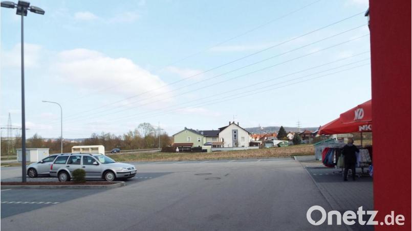 Die landwirtschaftliche Fläche, vom bestehenden Norma-Parkplatz aus Richtung Amberg gesehen, soll bis zu den Häusern bebaut werden soll. Rechts hinten soll ein Doppelwohnhaus entstehen. Bild: e