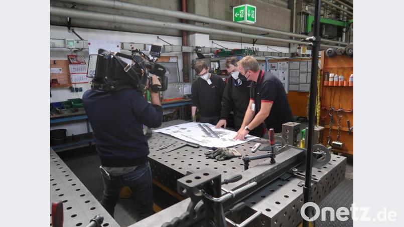 Die Schutzmaßnahmen für die Mitarbeiter der Horn Glass Industries AG wurden von einem ZDF-Team festgehalten. Rainer Sommer (Bereichsleiter Fertigung) demonstrierte mit seinen Mitarbeitern das erforderliche gemeinsame Arbeiten an einem Werkstück und erklärte dabei das neuartige Tracker-System. Bild: Firma Horn Glass Industries/exb