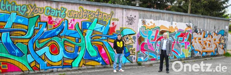 Eine Seite der Bretterwand am Skaterplatz hat der Graffity-Künstler Fabian Moller (links) schon gestaltet. Bürgermeister Johannes Reger (rechts) freut sich auf mehr. Bild: njn