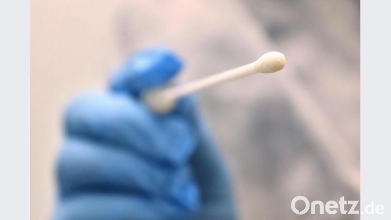 Ein Arzt hält einen Tupfer für einen Coronatest-Abstrich. Bild: Karl-Josef Hildenbrand/dpa