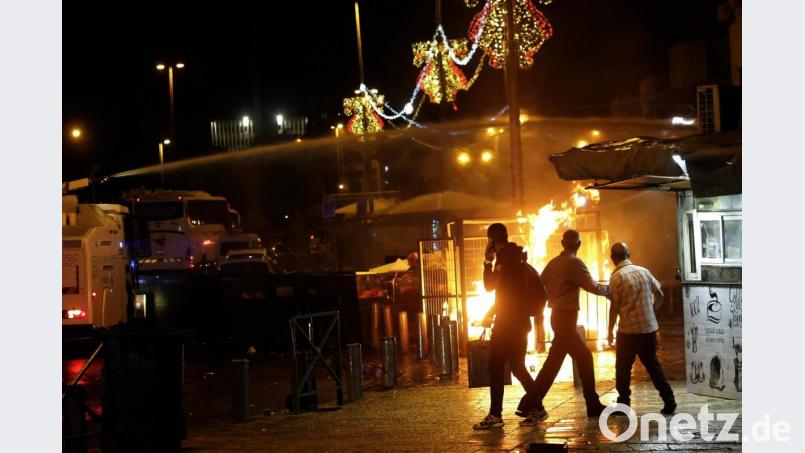 Ein Wasserwerfer der israelischen Polizei wird in der Nähe des Damaskustors in der Altstadt von Jerusalem eingesetzt, als ein Feuer während Zusammenstößen zwischen der Polizei und palästinensischen Demonstranten brennt. Bild: Mahmoud Illean/AP/dpa