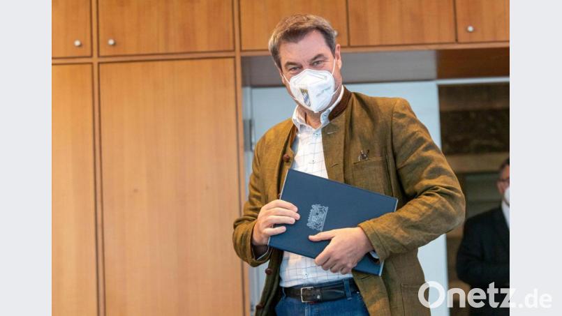 Markus Söder (CSU), Ministerpräsident von Bayern, hält auf seinem Weg zur Sitzung des bayerischen Kabinetts eine blaue Mappe mit dem Staatswappen in der Hand. Bild: Peter Kneffel/dpa