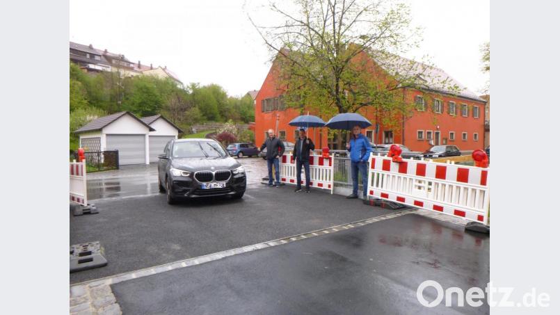 Bürgermeister Robert Lindner fährt in seinem schwarzen Dienstwagen als Erster über die neue Floßbach-Brücke. Markus Schieder (rechts) von der Zwick-Ingenieure GmbH aus Weiden hat das Bauwerk mängelfrei abgenommen. Das freut auch Bauleiter Thomas Fütterer (Mitte) und Projektleiter Manfred Brunner von der Firma Gollwitzer Spezialtiefbau. Bild: tss