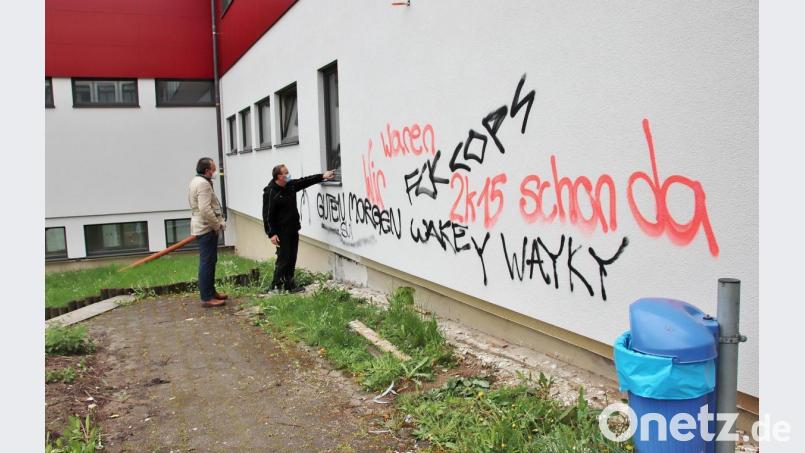 Bürgermeister Frank Zeitler (links) und Schulhausmeister Erich Troidl inspizierten die Schmierereien, die nicht nur die Außenwand, sondern auch einige Fenster der Schule beschädigt haben. Bild: Thomas Dobler