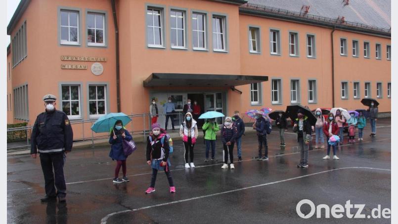 Polizeioberkommissar Wolfgang Trottmann von der PI Tirschenreuth (links) erklärte den Kindern die neuralgischen Punkte an den neuen Schulwegen zum Pfarrzentrum, Fitnessstudio und Bayer-Saal. Verabschiedet wurde die Gruppe von Rektorin Inge Dick, Elternbeiratsvorsitzendem Nik Landstorfer, Bürgermeister Toni Dutz und Simone Collignon (im Hintergrund von links). Bild: wro