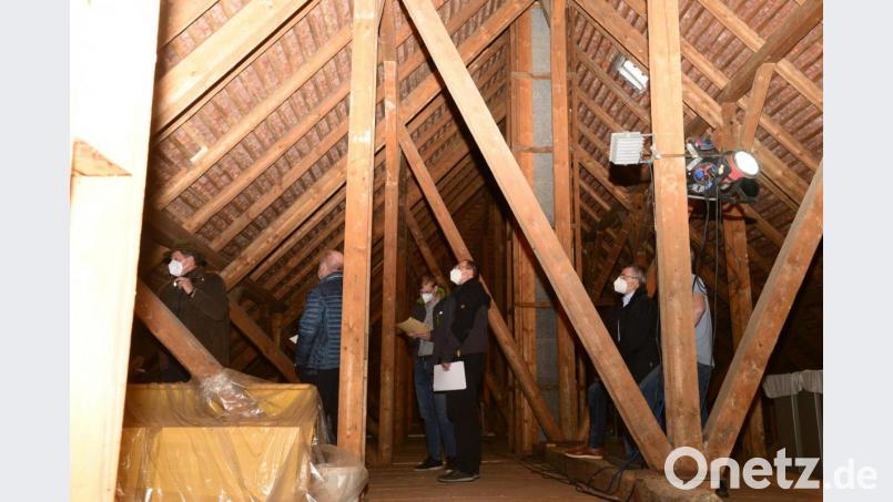 Gewaltig sieht das Gebälk der Alten Turnhalle aus. Zimmermeister Hans Hanauer (links) erläutert Bürgermeister Reiner Gäbl (rechts, mit Maske) und den Bauausschussmitgliedern den Umfang der Dachdeckerarbeiten. Bild: bey