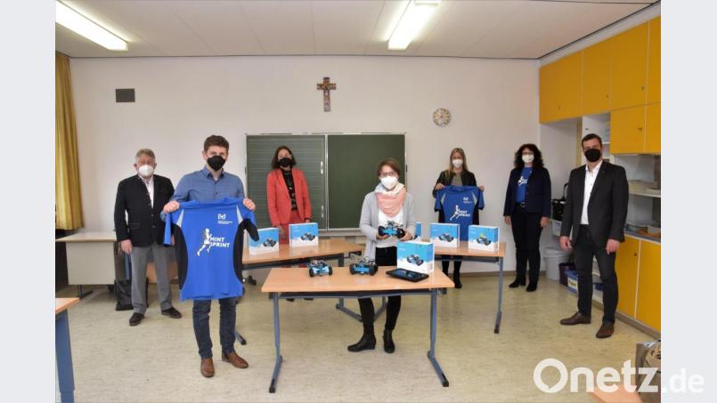Informatiklehrerin Julia Eiber (Mitte) zeigt einen der neun Lernroboter der Mittelschule Windischeschenbach. Bild: fz
