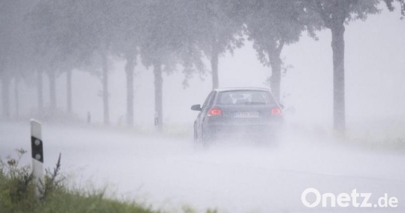 Ein Auto fährt bei Starkregen über eine Landstraße. Symbolbild: Julian Stratenschulte/dpa