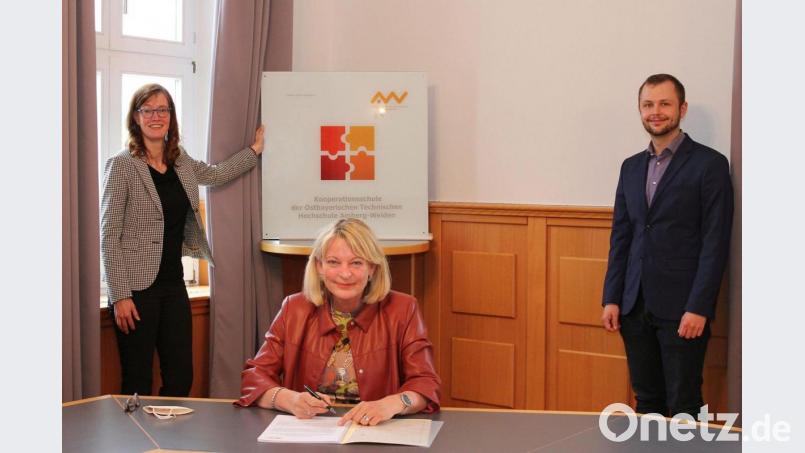 Professorin Andrea Klug (sitzend), Präsidentin der OTH Amberg-Weiden, unterzeichnet im Beisein von Studiengangsleiterin Professorin Mandy Hommel und Michael Abler, wissenschaftlicher Mitarbeiter im Bereich Berufspädagogik, die Kooperationsvereinbarungen. Bild: Wiesel/OTH Amberg-Weiden/exb