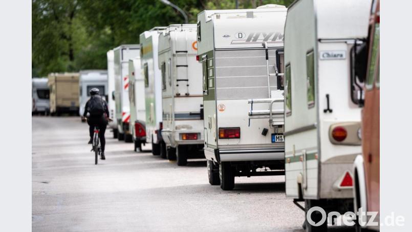 Ein Radfahrer fährt in einer Straße an geparkten Wohnmobilen vorbei. Archivbild: Matthias Balk/dpa