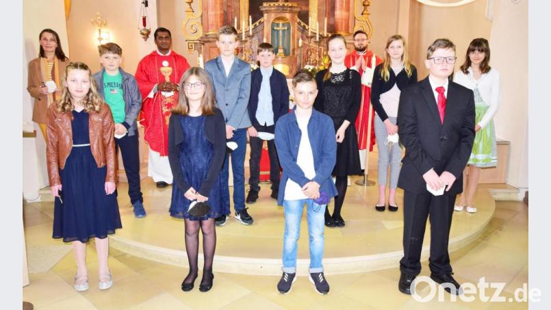 Die gefirmten Sechstklässler mit Pfarrer Johannes Arweck (Vierter on rechts), Pfarrvikar Thomas Sanikommula (Vierter von links) und Waltraud Geitner (zuständig für die außerschulische Firmvorbereitung). Bild: no