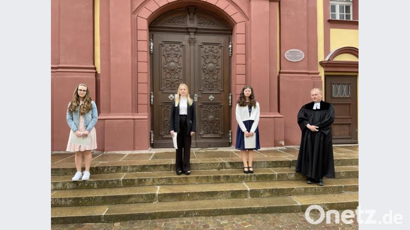Pfarrer Joachim von Kölichen mit den drei Konfirmandinnen vor dem Eingangsportal der Paulanerkirche. Bild: Paulanerkirche/exb