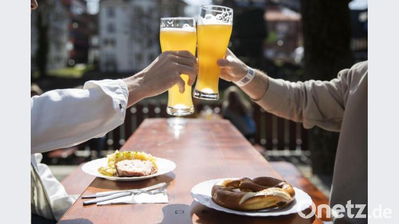 Dieses Bild wird man ab kommender Woche auch im Landkreis Amberg-Sulzbach wieder sehen können: Zwei Menschen sitzen in einem Biergarten und prosten sich zu. Symbolbild: Tom Weller/dpa