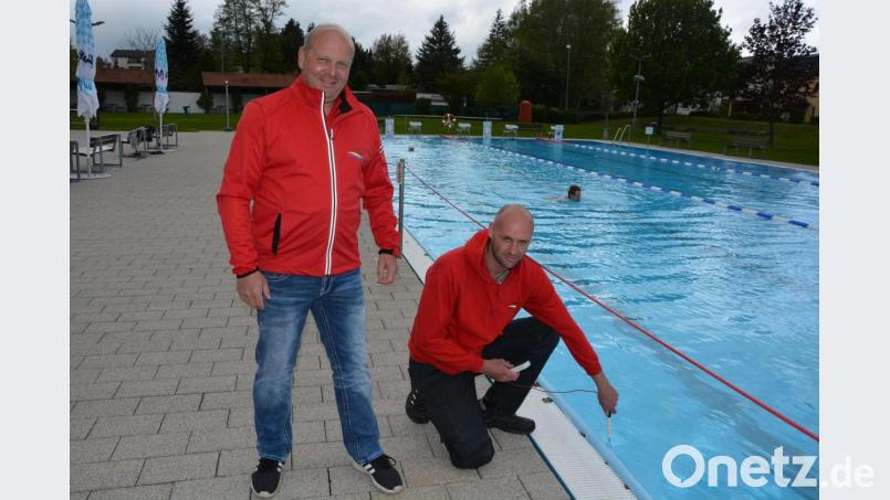 Bademeister Gerald Riederer (rechts) beim Messen der Wassertemperatur im Egrensisbad: Zur Eröffnung am Dienstagvormittag war das Wasser genau 24,1 Grad warm – bei einer Außentemperatur von 10 Grad. Links im Bild Riederers Kollege Andreas Hoschek. Bild: jr