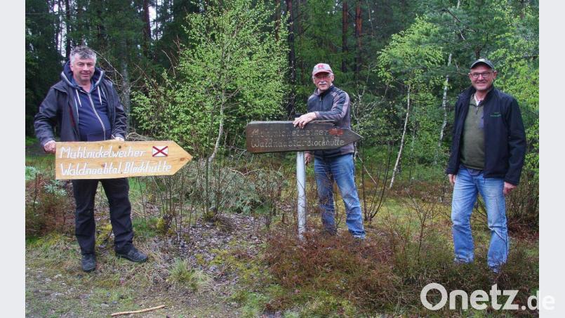 OWV-Vorsitzender Peter Hasenfürter (von rechts) sowie der für Ruhebänke zuständige Banklwart Karl Bauer und Wanderwegewart Stefan Scharnagl legen gemeinsam Hand an, um die schadhafte Hinweistafel am Mühlnicklweiher durch eine neue zu ersetzen. Bild: wro