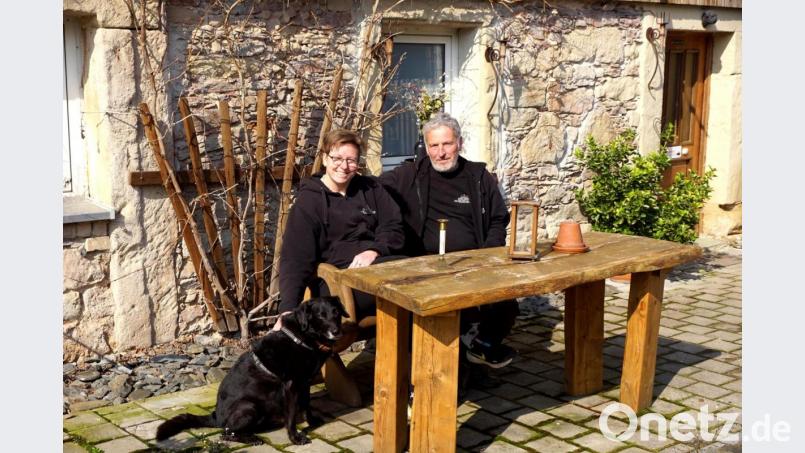 Alexandra und Rainer Walberer auf einer gemütlichen Bank mit einen ihrer beiden Hunde vor der über 500 Jahre alten Lienlasmühle. Bild: bkr