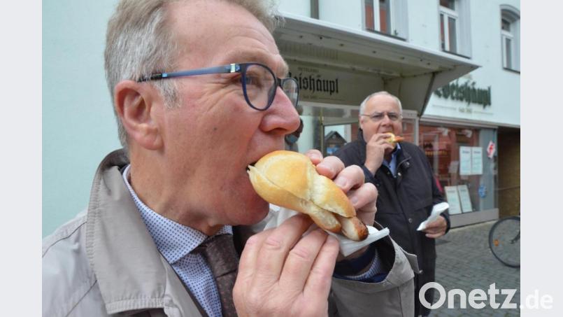 Die beiden Bürgermeister Reinhold Wildenauer und Lothar Höher genießen die erste Bratwurstsemmel in der Fußgängerzone. Seit Donnerstag ist der Verzehr wieder direkt vor Ort möglich, da die Maskenpflicht aufgehoben (außer an Markttagen) wurde. Bild: Kunz