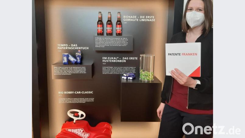 Vor einer „Warenauslage“ präsentiert wissenschaftliche Mitarbeiterin Christina Heydenreich den umfassenden Begleitband zur Ausstellung, der kostenlos mitgenommen werden darf. Bild: gis